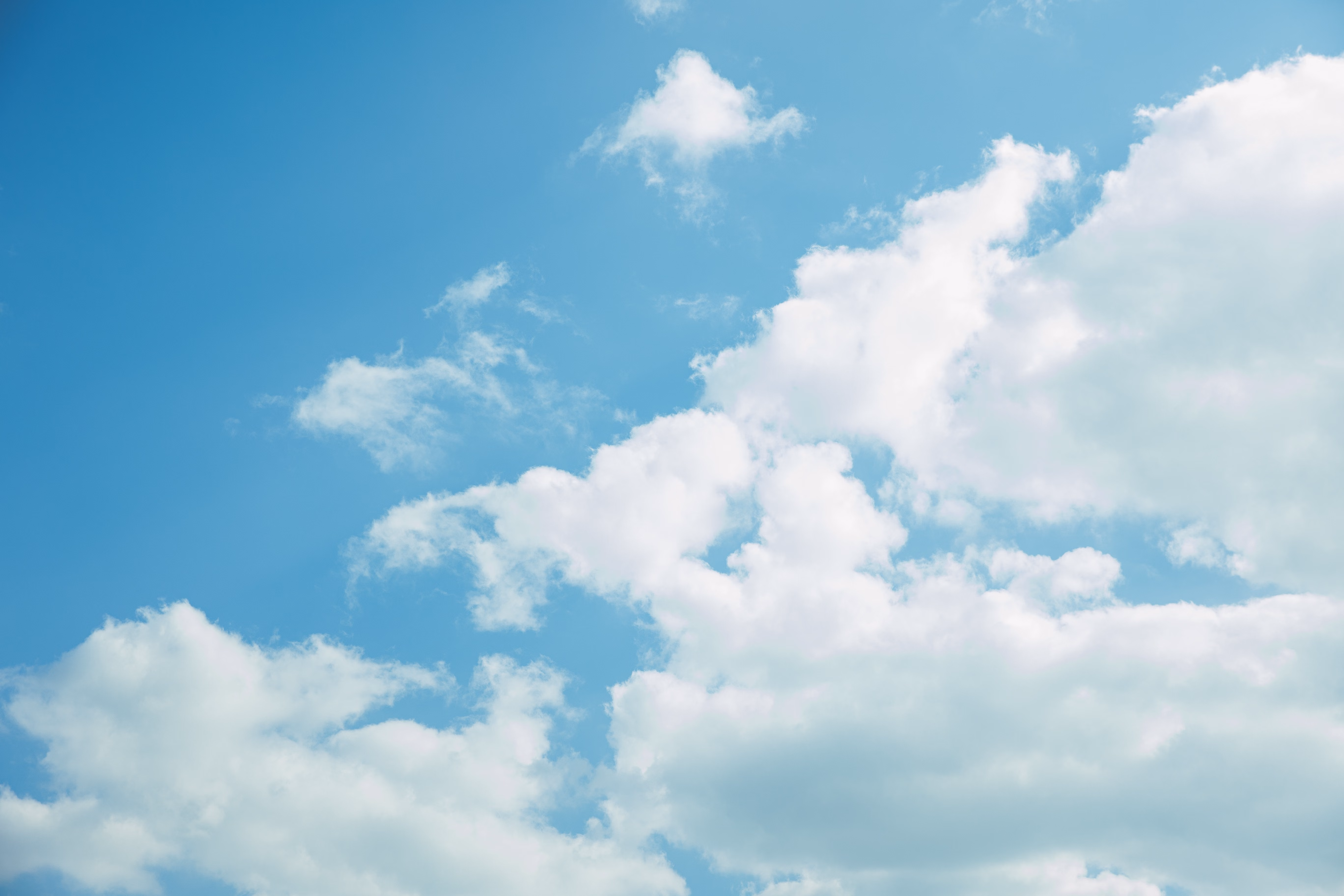 why the sky appears blue A bright blue sky with a few white clouds photographed from below