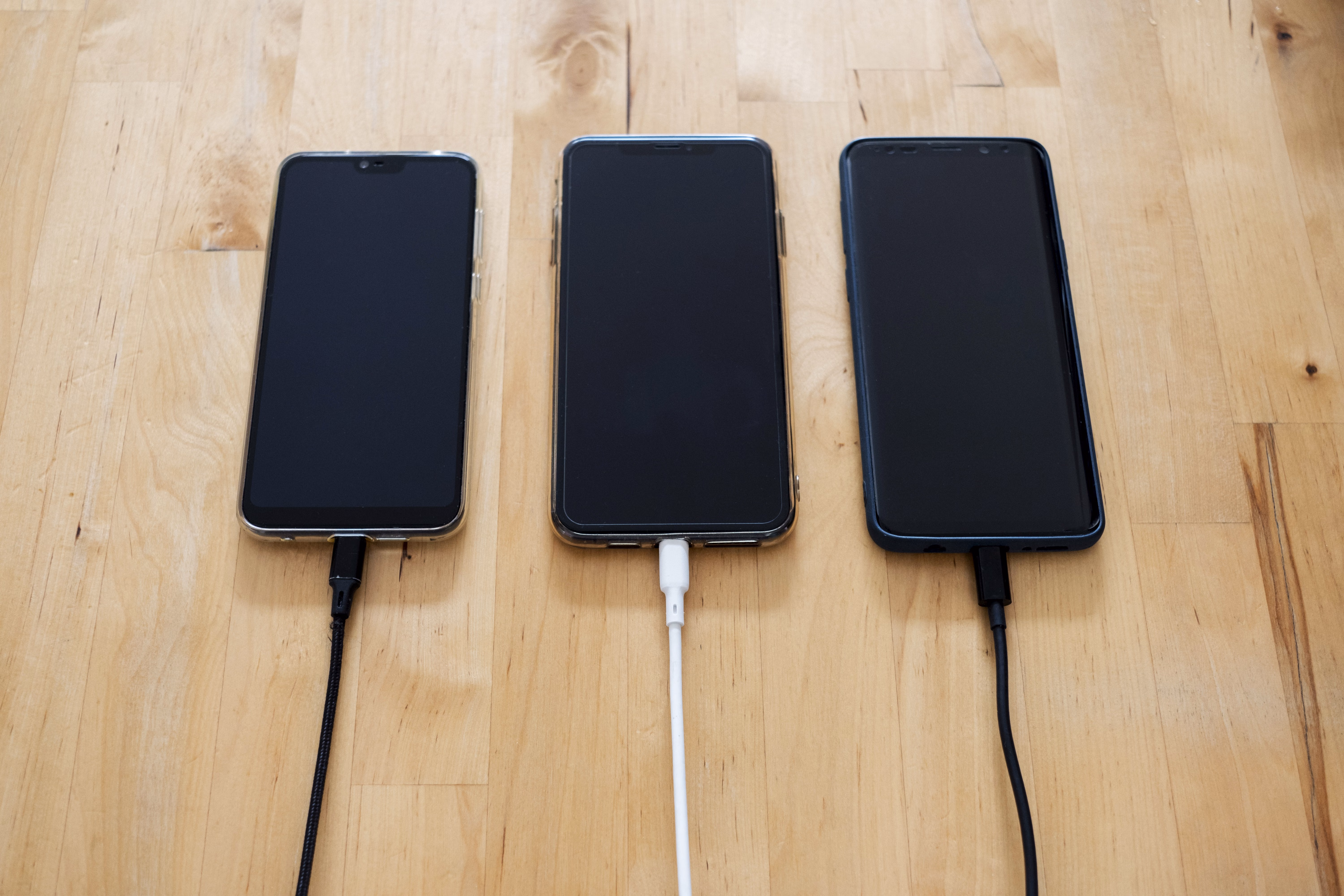 charging smartphone battery A smartphone charging on a desk connected by a cable, battery percentage showing on screen